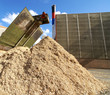 bio power plant with storage of wooden fuel against blue sky