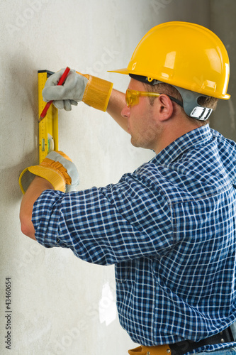 Foto: worker does layout on concrette worker does layout on concrette