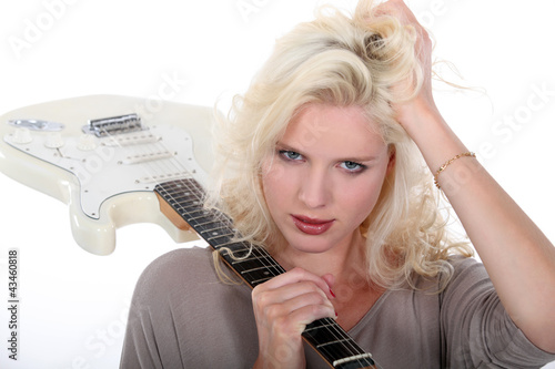 Photo: Blond woman holding electric guitar over shoulder Blond woman holding electric guitar over shoulder
