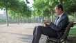 Video: Young businessman working on tablet computer in the park Young businessman working on tablet computer in the park
