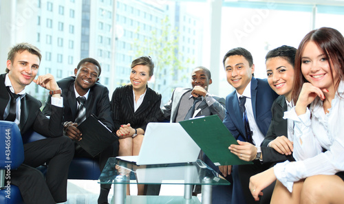Photo: Satisfied proud business team looking at camera Satisfied proud business team looking at camera