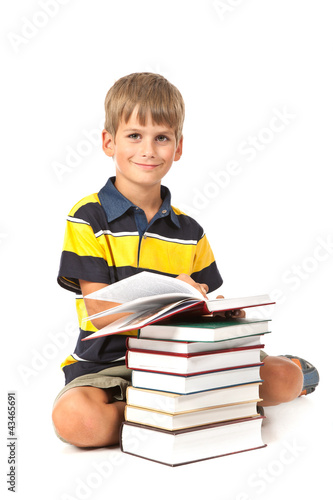 Foto: Schoolboy is sitting on books Schoolboy is sitting on books