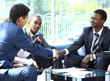 Two business man shaking hands with his team in office
