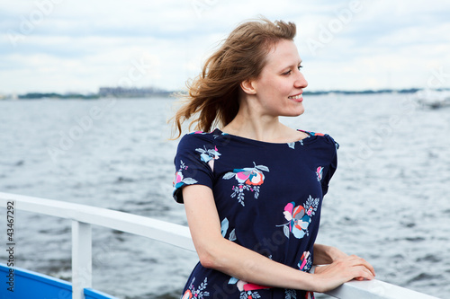 Photo: Girl standing on the deck of cruise yacht on wind and looking fa Girl standing on the deck of cruise yacht on wind and looking fa