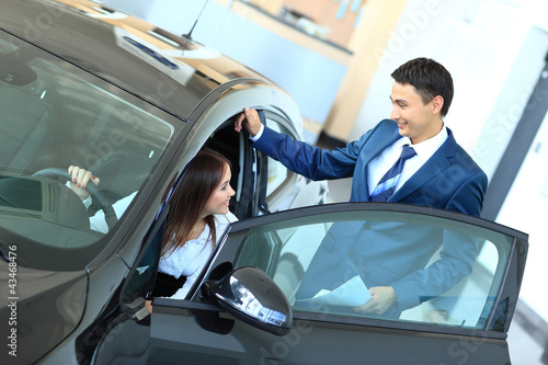 Photo: Woman buying a new car Woman buying a new car