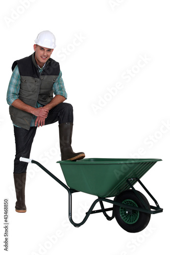 Foto: Construction worker with empty wheelbarrow Construction worker with empty wheelbarrow