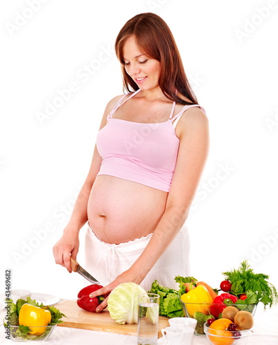Photo: Pregnant woman preparing food . Pregnant woman preparing food .