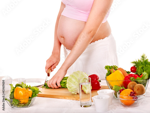 Foto: Pregnant woman preparing food . Pregnant woman preparing food .