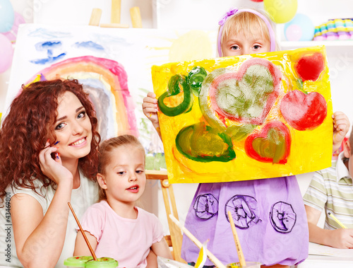 Photo: Child painting at easel. Child painting at easel.