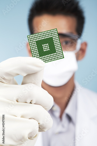 Photo: Scientist showing a microchip computer Scientist showing a microchip computer