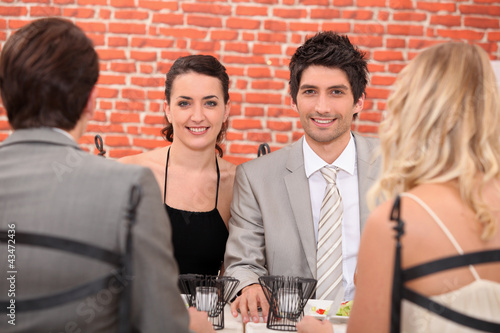 Photo: Two couple having meal in restaurant Two couple having meal in restaurant