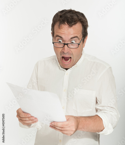 Photo: Scared man reading a document Scared man reading a document