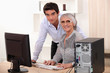 Young man and older woman using a computer