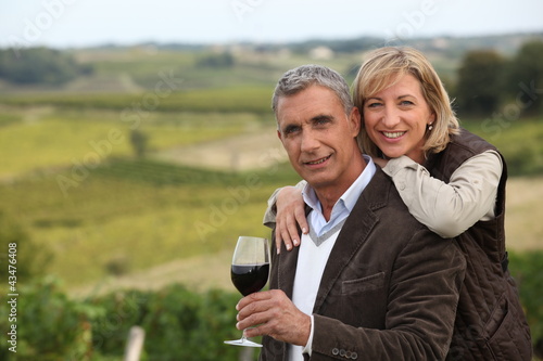 Foto: Couple with wine glass in front of vineyard Couple with wine glass in front of vineyard