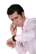 businessman under pressure consulting his watch