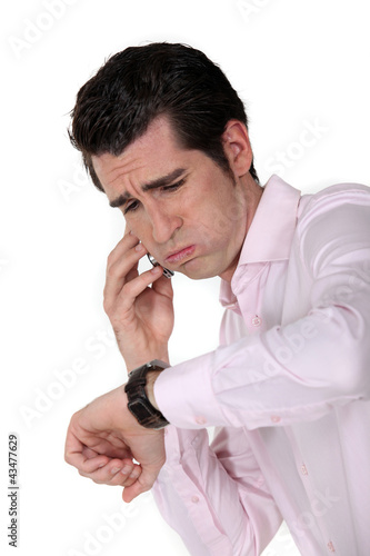 Foto: businessman under pressure consulting his watch businessman under pressure consulting his watch