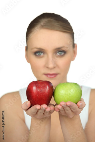 Photo: Blurry woman showing apples on white background Blurry woman showing apples on white background
