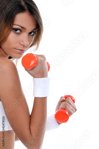 Foto: Young woman lifting weights Young woman lifting weights