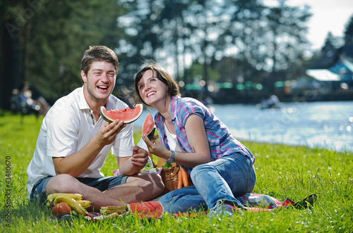 Photo: happy young couple having a picnic outdoor happy young couple having a picnic outdoor