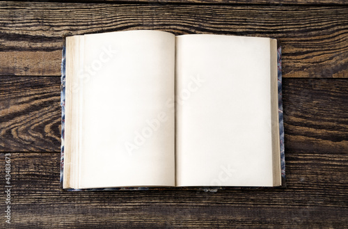 Photo: Aged book on wooden table Aged book on wooden table