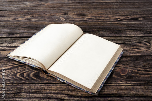 Photo: Aged book on wooden table Aged book on wooden table