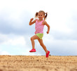 Foto: Little girl running in sand Little girl running in sand