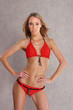 A young blond Caucasian woman posing in a red swimsuit