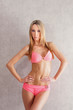 A young blond Caucasian woman posing in a pink swimsuit