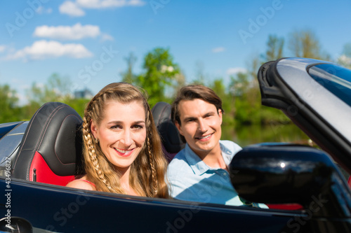 Photo: Young couple with cabriolet in summer on day trip Young couple with cabriolet in summer on day trip