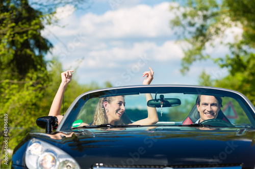 Photo: Young couple with cabriolet in summer on day trip Young couple with cabriolet in summer on day trip