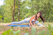 Beautiful young woman doing  yoga exercising  in forest