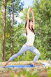 Beautiful young woman doing  yoga exercising  in forest