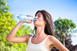 Young  beautiful dark-haired woman drinking water