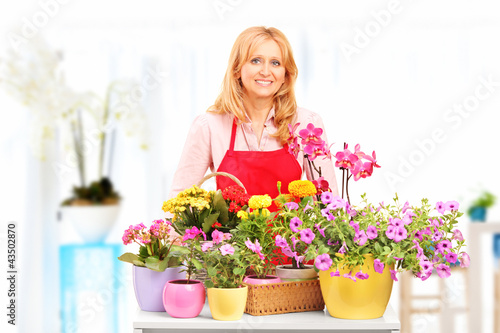 Photo: Female horticulturist standing with flowers Female horticulturist standing with flowers