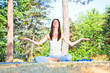 Young woman doing yoga meditation in forest