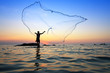 throwing fishing net during sunrise, Thailand