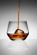 Photo: Whisky pouring on ice in glass. Whisky pouring on ice in glass.