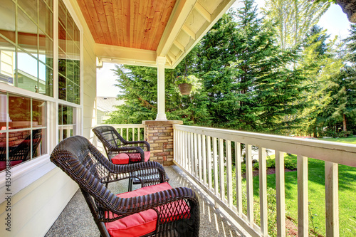 Photo: Front porch with brown chairs and red cushions. Front porch with brown chairs and red cushions.