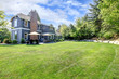 Blue large house with backyard and green landscape.