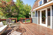 House exterior with large open deck with outdoor furniture.