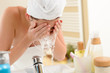 Foto: Woman splashing face with water in bathroom Woman splashing face with water in bathroom