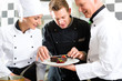 Team von Köchen mit Dessert in Küche