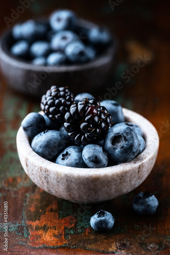 Photo: Blueberries and blackberries in small dishes Blueberries and blackberries in small dishes