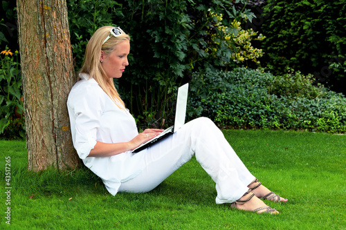 Foto: Frau mit Laptop Computer im Garten Frau mit Laptop Computer im Garten
