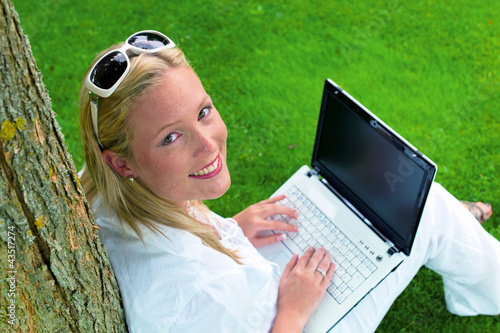 Foto: Frau mit Laptop Computer im Garten Frau mit Laptop Computer im Garten
