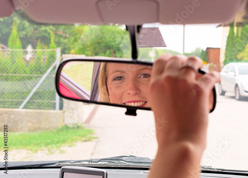 Foto: Frau richtet den Rückspiegel im Auto Frau richtet den Rückspiegel im Auto