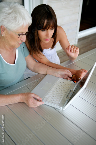 Foto: Young woman teaching her grandmother computer skills Young woman teaching her grandmother computer skills