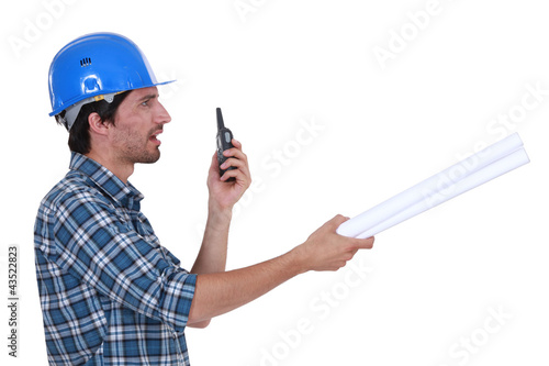 Photo: construction supervisor talking on his walkie talkie construction supervisor talking on his walkie talkie