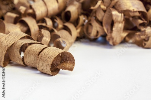 Photo: wooden shaving on pine wood background wooden shaving on pine wood background