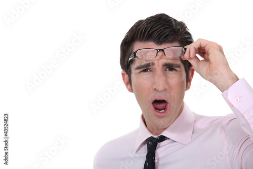 Foto: Man taking his glasses off in dismay Man taking his glasses off in dismay